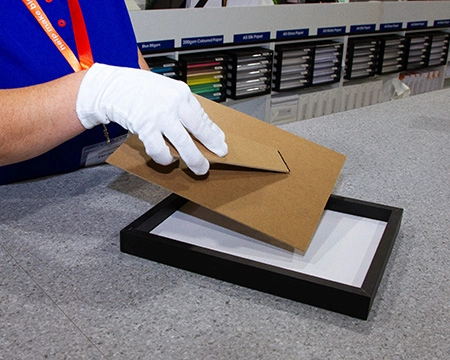 Team member putting an image in a frame