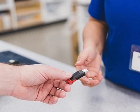Customer handing a USB to a team member