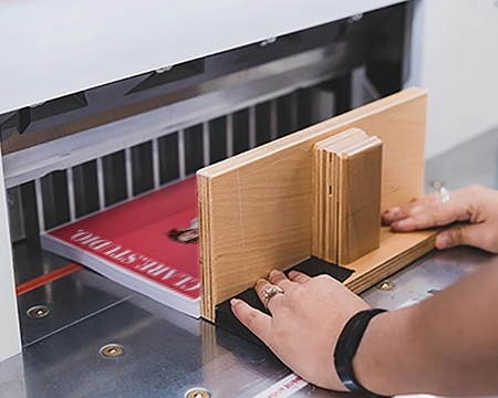  Team member guillotining a stack of paper